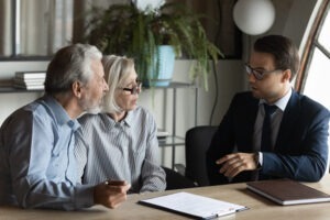 An investment fraud lawyer in Worcester speaking with an elderly couple about their case.