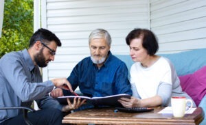 An investment fraud lawyer in Memphis speaking with an elderly couple about their case.