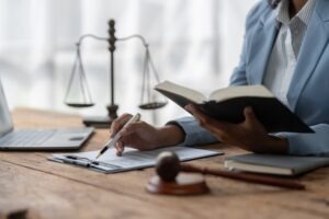A closeup of an investment fraud lawyer reading a book containing North Carolina’s securities fraud state laws.