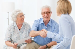A senior couple shaking hands with a New York churning lawyer.