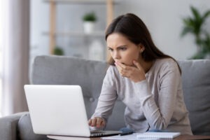 Person looking at a laptop screen and concerned about what to do after their Coinbase account was hacked