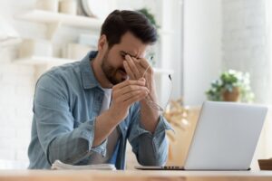 Man sits at a laptop and researches how to report a hacked crypto account