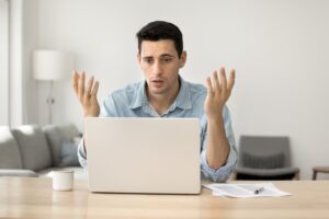 Man sits at desk and uses laptop to research whether he can file a lawsuit against Bitstamp.