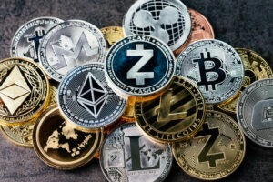 A pile of cryptocurrency coins, with someone nearby wondering if Binance can recover their stolen crypto