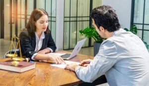 Man sits across the desk from an investment fraud lawyer.